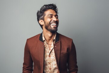 Fototapeta premium Lifestyle portrait of an Indian man in his 30s in a minimalist background