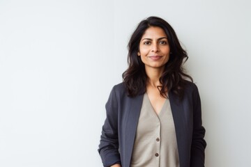 Lifestyle portrait of an Indian woman in her 40s in a minimalist background