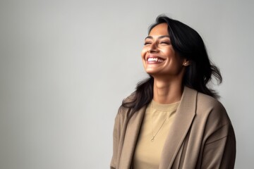 Lifestyle portrait of an Indian woman in her 40s in a minimalist background