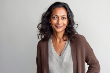 Obraz premium Lifestyle portrait of an Indian woman in her 40s in a minimalist background