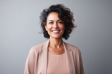 Fototapeta premium Medium shot portrait of an Indian woman in her 50s in a minimalist background