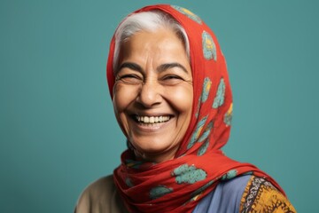 Lifestyle portrait of an Indian woman in her 50s wearing hijab in a minimalist background