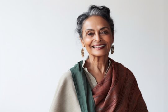 Lifestyle portrait of an Indian woman in her 50s in a minimalist background
