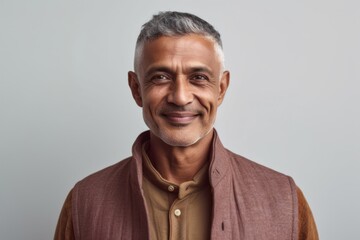 Obraz premium Medium shot portrait of an Indian man in his 50s in a minimalist background