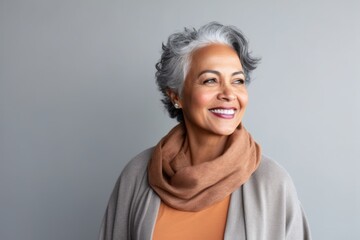 Fototapeta premium Medium shot portrait of an Indian woman in her 60s in a minimalist background