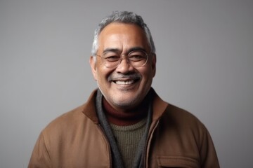 Medium shot portrait of an Indian man in his 60s in a minimalist background