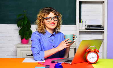University professor drinking coffee in classroom. School teacher or student in glasses. Smiling...