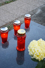 Red votive candles on the grave