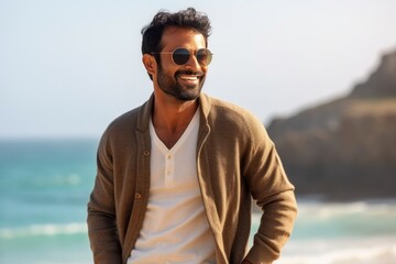 Medium shot portrait of an Indian man in his 30s in a beach 