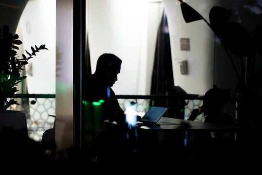 Man working late night in financial district, with laptop