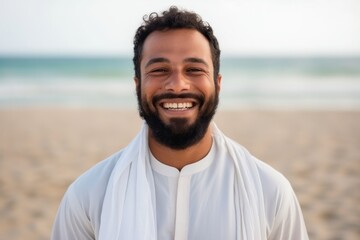 Medium shot portrait of an Indian man in his 30s wearing hijab in a beach 