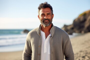 Portrait of handsome mature man standing on beach at the day time