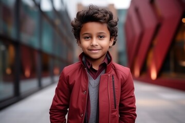 Portrait of a boy in a red coat on a city street