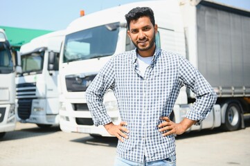 Young indian man standing in front of his truck.