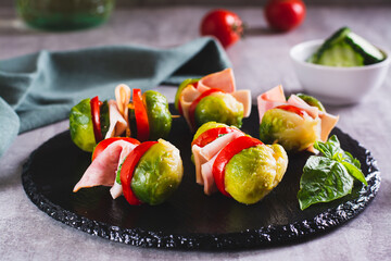Brussels sprouts, tomatoes, cucumber and bacon sliders on slate board