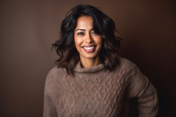 Fototapeta premium Beautiful brunette woman in a brown sweater on a brown background