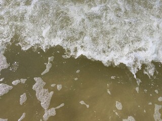a foamy wave on the sand of the north sea beach