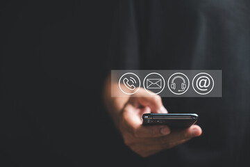 Website contact us page featuring customer support hotline connections on smartphone. Icons of email, phone call and address symbolize effective communication. Banner for online business and marketing