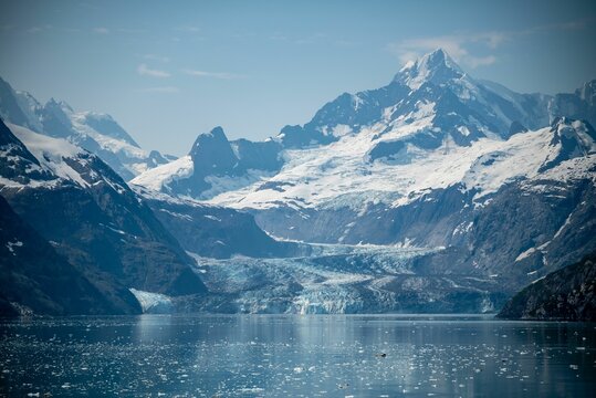 large mountains on both sides of the water and some ice floes