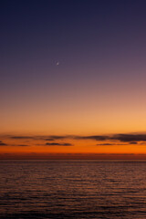 Obraz premium The moon above ocean during sunset