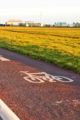 Vertical of a cycle path along a green field in Brighton, England at sunset