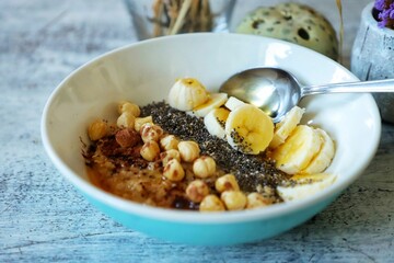 Closeup of a typical English breakfast with porridge, milk, nuts and banana