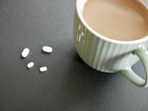 Top View Of A Cup Of Coffee With Antipsychotic Meds On The Table