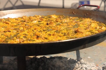 Street traditional cooking with a large stainless steel frying pan in Valencia