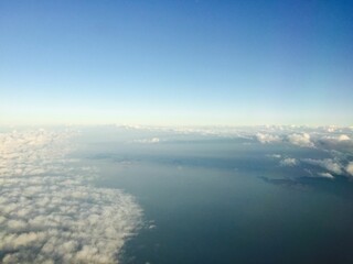 Aerial view of the ocean's surface with billowing clouds above