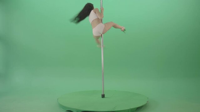 Woman spinning upside down on pole on green screen, inverted pole acrobatics chroma key footage