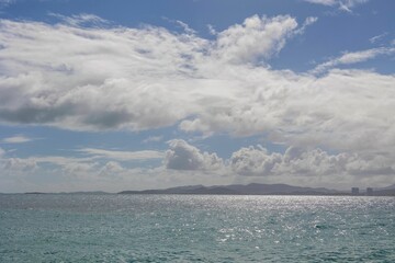 Scenic view of the ocean with clouds and mountains on either side