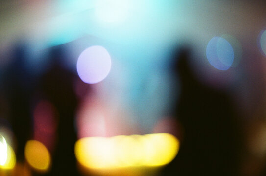 abstract analogue photography: Blurred Silhouettes of Dancing Crowd, energetic concert vibes