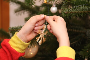 Kind schm&uuml;ckt den Tannenbaum, Strohstern, Baumschmuck, Weihnachten, Lichter
