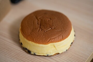 Closeup of a chocolate frosted cheesecake on a wooden table