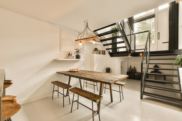 a dining table and chairs in a small room with stairs leading up to the second floor, as well as...