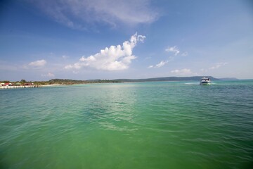 Scenic view of the turquoise ocean with boats lined along the beach