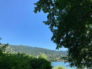 Obraz premium Picture features a lush forested mountain range with a tranquil pond in the foreground