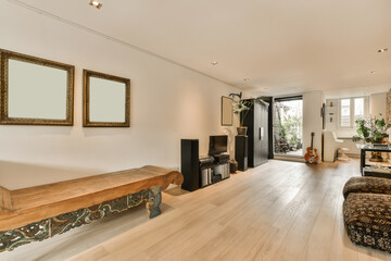 a living room with wood flooring and white walls in the center of the room is a large mirror on the wall