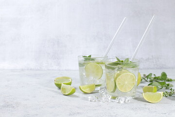 Detox drink with mint, lime and orange on a light table, majito or cocktail improves metabolism and promotes weight loss, healthy lifestyle concept, selective focus