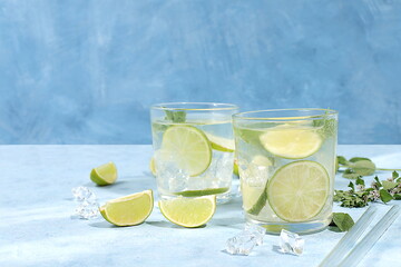 Detox drink with mint, lime and orange on a light table, majito or cocktail improves metabolism and...