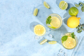 Detox drink with lemon, mint, lime and orange on a light table, majito or cocktail improves metabolism and promotes weight loss, healthy lifestyle concept, selective focus