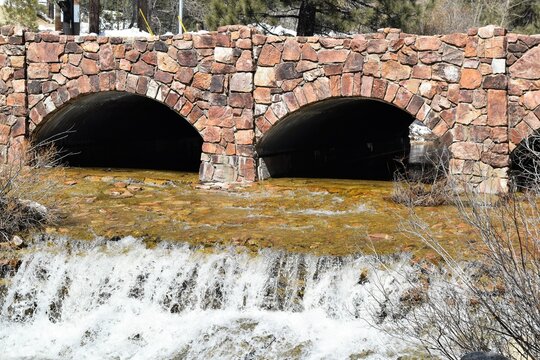 Water Cascades Beneath Old Stone Bridge