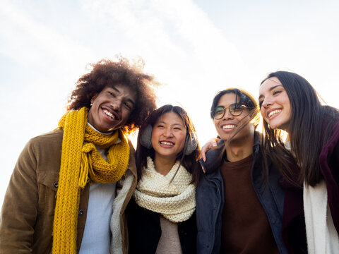 Group of young diverse teenage friends in winter having a good time in the street 