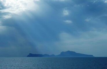Naklejka na ściany i meble Sun breaking through clouds on the Gulf of Naples