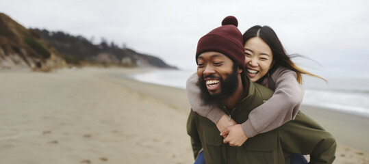 A multiracial couple of young individuals enjoying a fun time at the beach on an autumn afternoon, moments of happiness in diversity,copy space