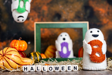 BOO ghost toys with pumpkins and autumn leaves. HELLOWEEN lettering made up of nubics.