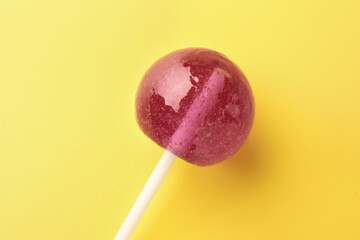 One tasty lollipop on yellow background, closeup