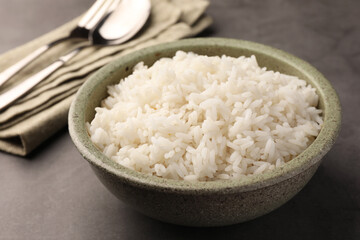 Delicious rice in bowl on grey table, closeup