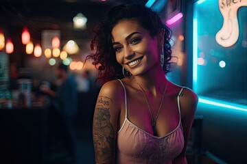 Young latina woman portrait with tattoo on shoulder standing on city street in evening. In background there are city lights.
