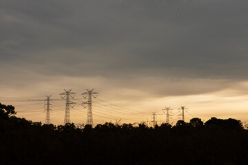 Silhouetted High-Voltage Power Lines Across the Landscape